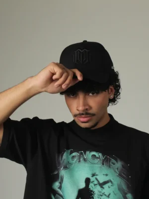 Plano frontal de gorra Monogram Black combinada con camiseta gráfica oversize de Moncyre Studios, moda urbana de alta gama.